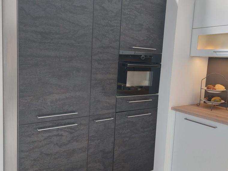 Grote, sfeervolle NOLTE showroomkeuken, lak wit mat in combinatie met donkere eik. Zitbank met lade's