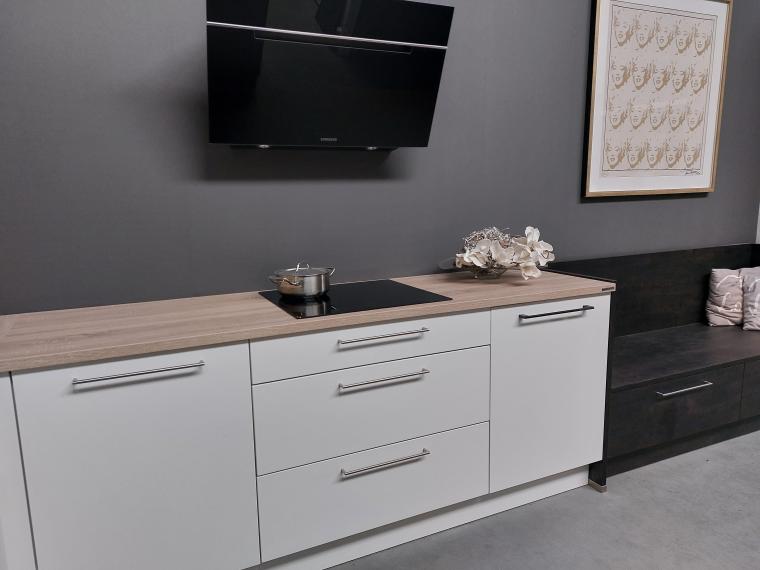 Grote, sfeervolle NOLTE showroomkeuken, lak wit mat in combinatie met donkere eik. Zitbank met lade's