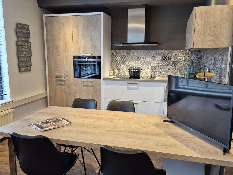 Moderne matwitte keuken icm houtstructuur en betonlook blad