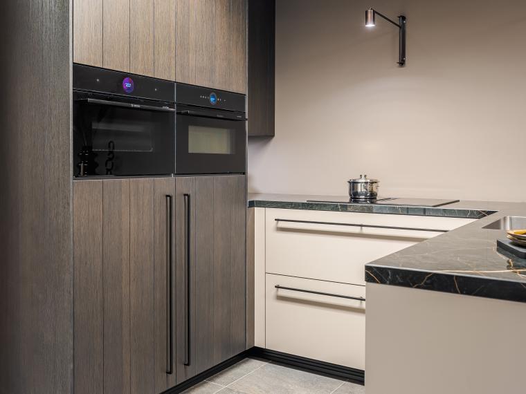 Strakke moderne keuken afgewerkt met stijlvolle hout look hoge kasten