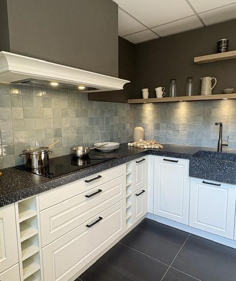 Klassieke keuken met een mat wit gelakt kaderdeur  en een zwart composiet blad