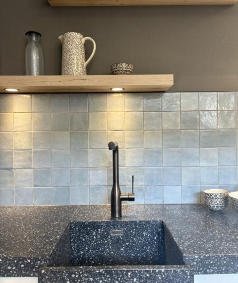 Klassieke keuken met een mat wit gelakt kaderdeur  en een zwart composiet blad
