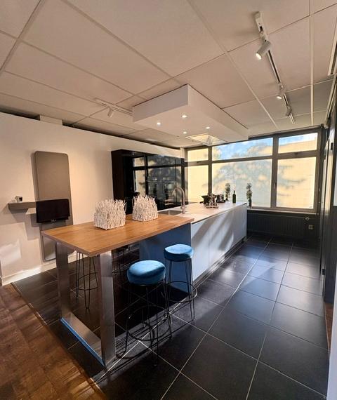 Moderne keuken met een lichtblauw eiland en keramiek marmer look blad, gecombineerd met zwarte hoogglans kasten