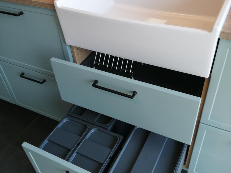 Formschöne Musterküche von Häcker, mit schwarzem Bügelgriff und Griffleiste, ohne Geräte