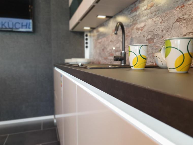 Designerstück mit Insel in Seidengrau HG, Backofen mit Dampfstoßfunktion, und Kochfeldabzug