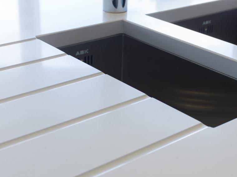 Keuken in houtstructuur melamine met contrasterend werkblad in composiet.