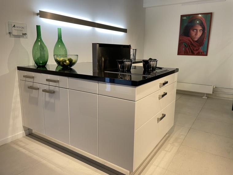 Moderne hoogglans lak keuken in speelse opstelling met granieten werkblad.