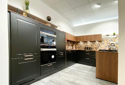 Schwarze Landhausküche mit Akzenten in Holz und Gold