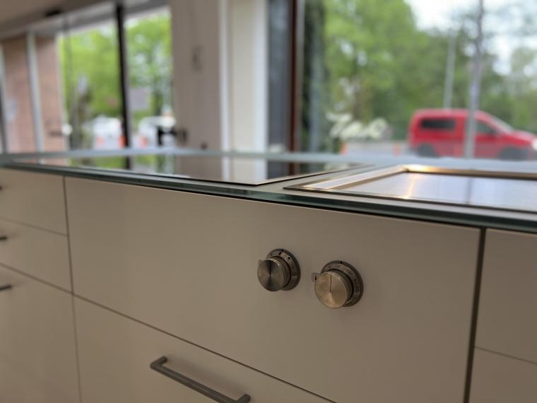 Exklusive LEICHT Musterküche mit Glas-Arbeitsplatte und hochwertigen Einbaugeräten von Gaggenau