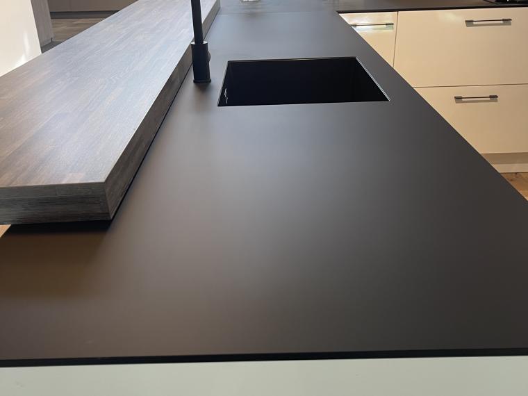 Keller  Hoogglans wit met zwart Fenix blad en halfopen kastenwand