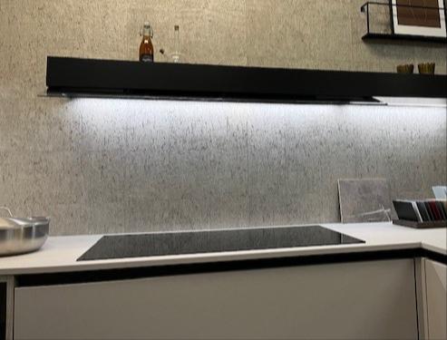 Een mooie moderne en complete keuken greeploos uitgevoerd, gecombineerd met hogekasten met beugelgrepen een luxe Servieskast zwart geanodiseerd glazen deur met spijlen.