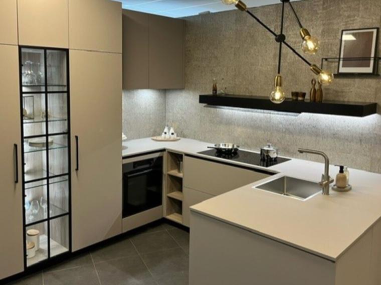 Een mooie moderne en complete keuken greeploos uitgevoerd, gecombineerd met hogekasten met beugelgrepen een luxe Servieskast zwart geanodiseerd glazen deur met spijlen.