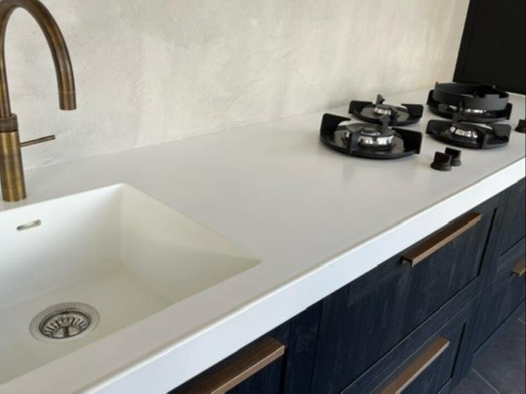 Moderne keuken voorzien van kunststof kaderfront gecombineerd met vlakke deur op hoge kasten.