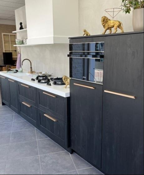 Moderne keuken voorzien van kunststof kaderfront gecombineerd met vlakke deur op hoge kasten.