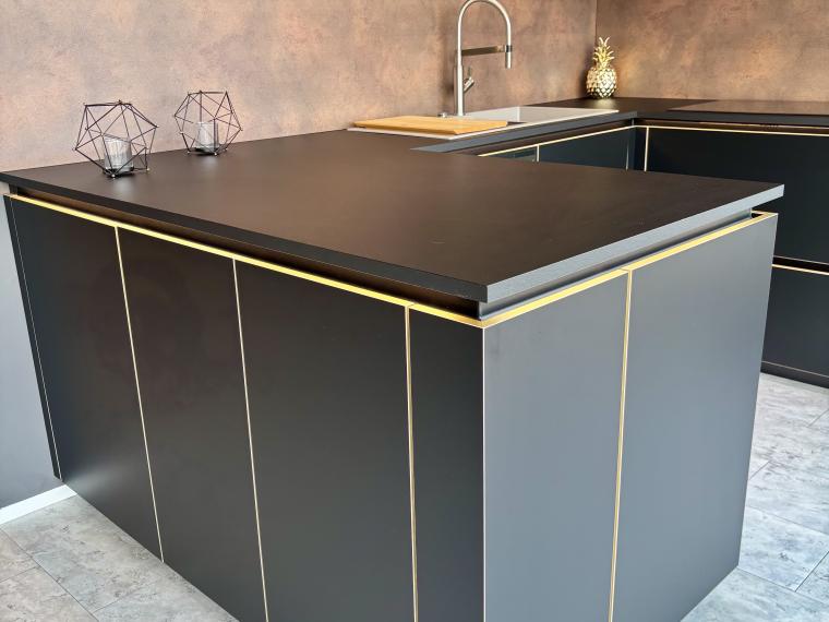 Elegante, moderne schwarze Küche mit goldenen Akzenten