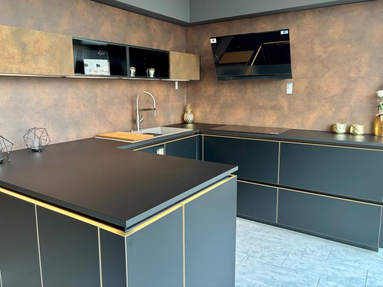 Elegante, moderne schwarze Küche mit goldenen Akzenten