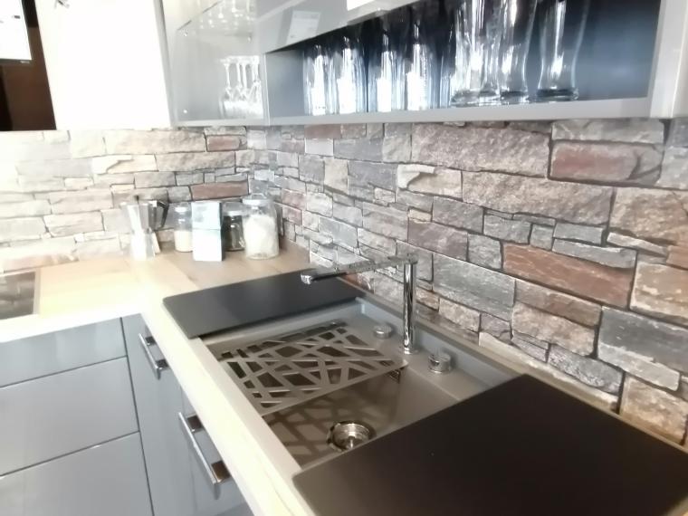 Modern - elegant - gradlinig. Anthrazitfarbene Küche in Lackausführung mit heller Arbeitsplatte in Holz-Optik und Nischenrückwand in Naturstein-Optik