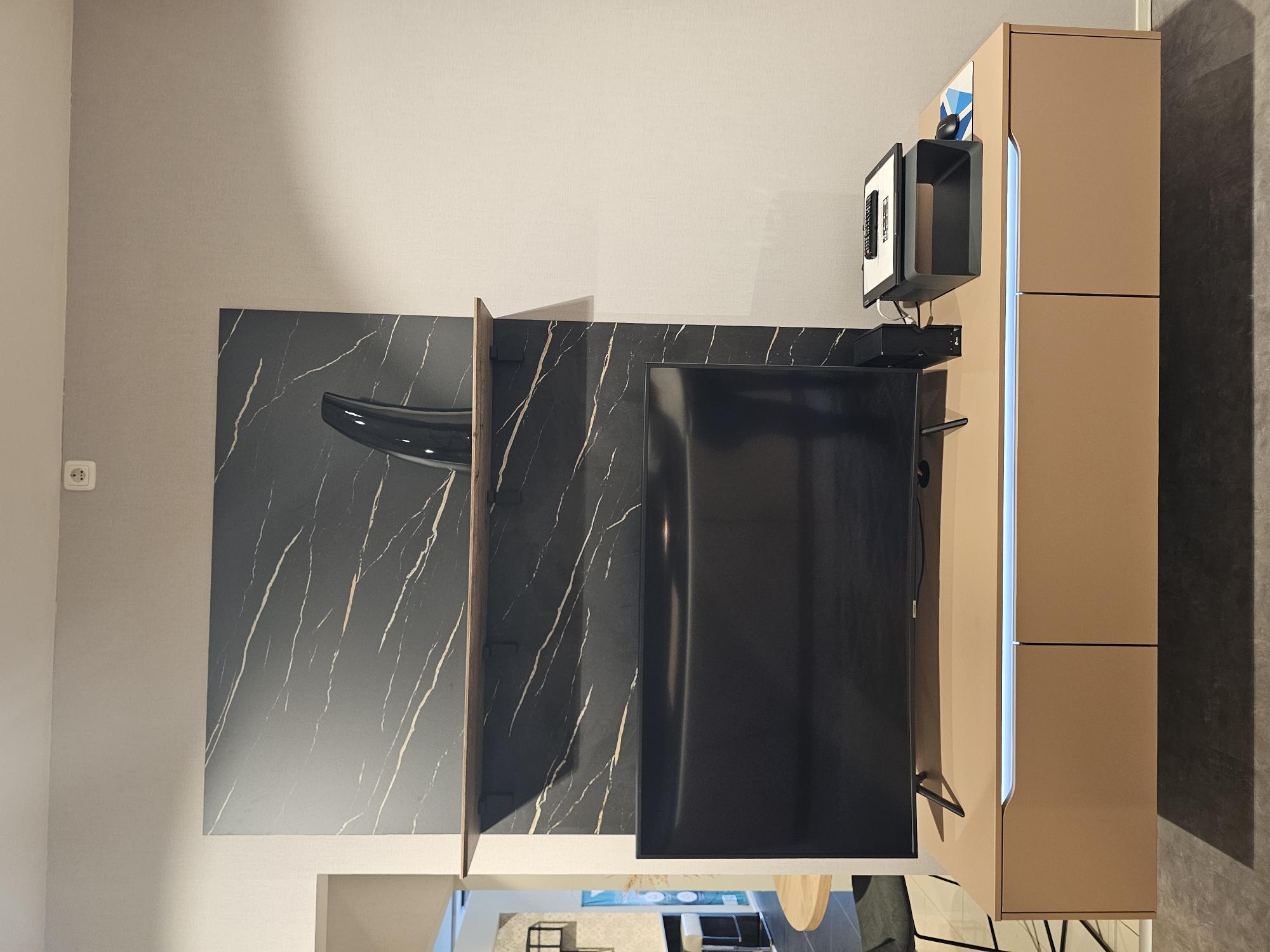 Lackmatte Premiumküche in Koralle inklusive Wohnzimmerwand