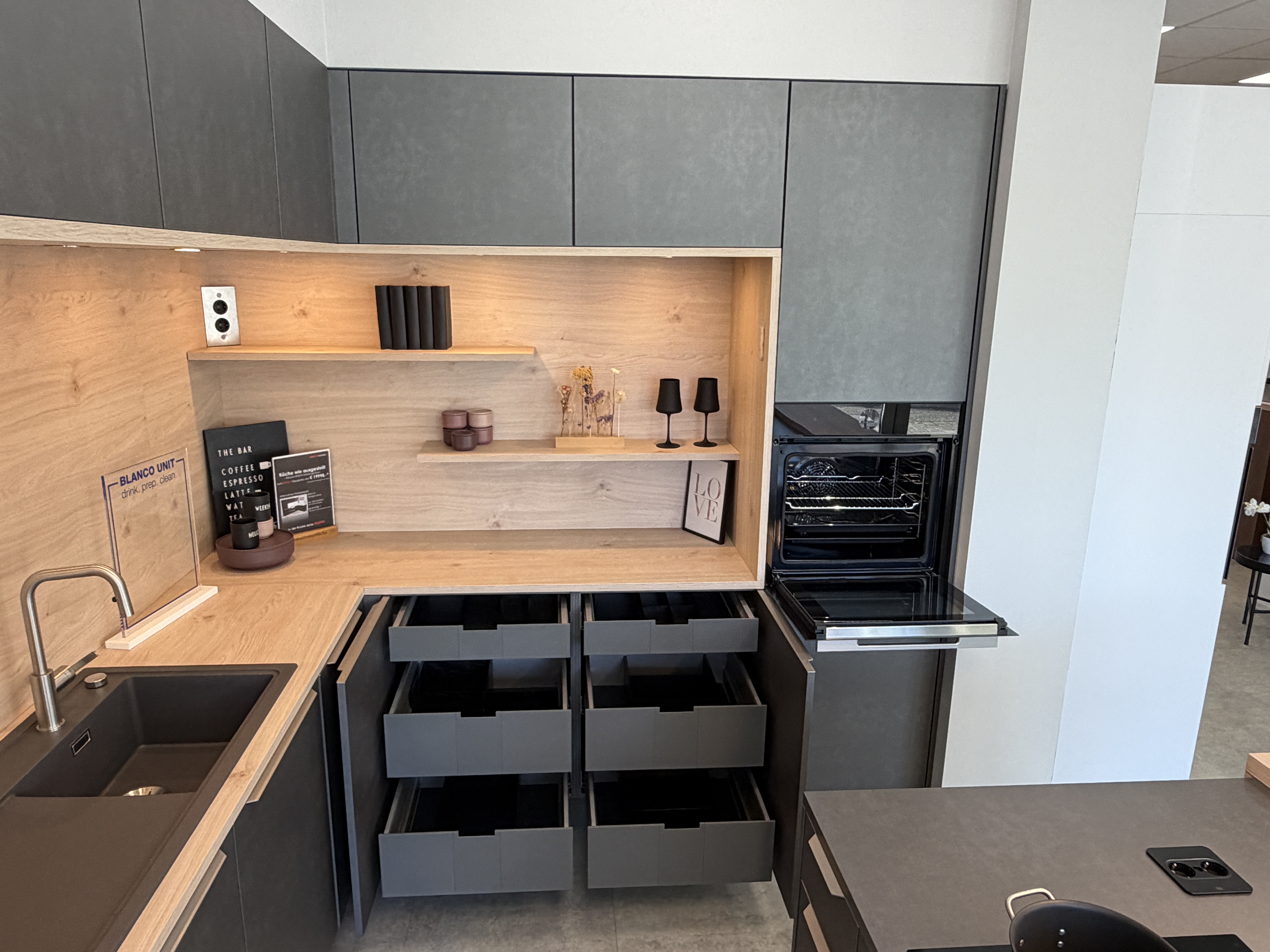 moderne Designküche in Stahl-Optik mit warmen Holzdekorelementen