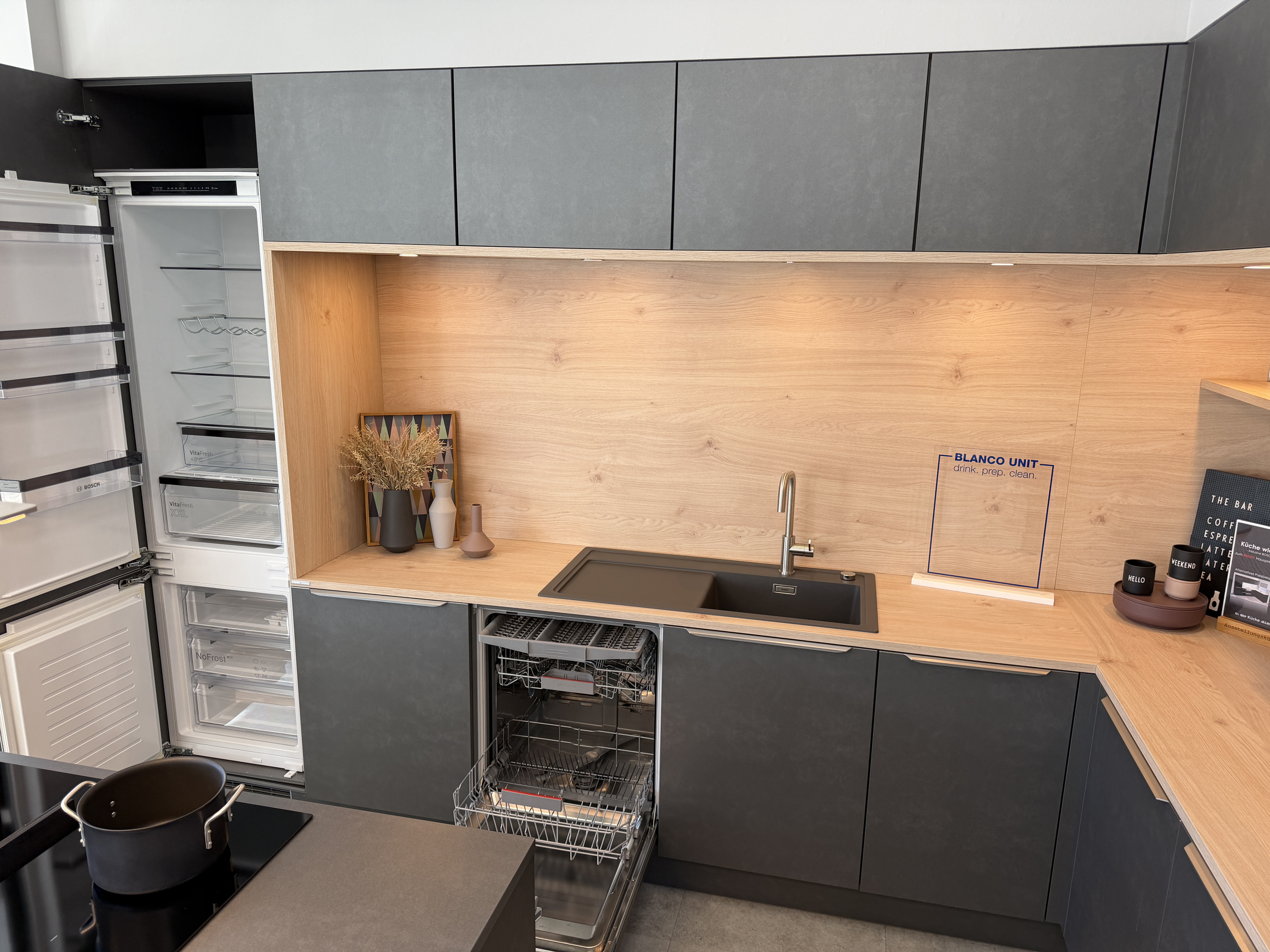 moderne Designküche in Stahl-Optik mit warmen Holzdekorelementen