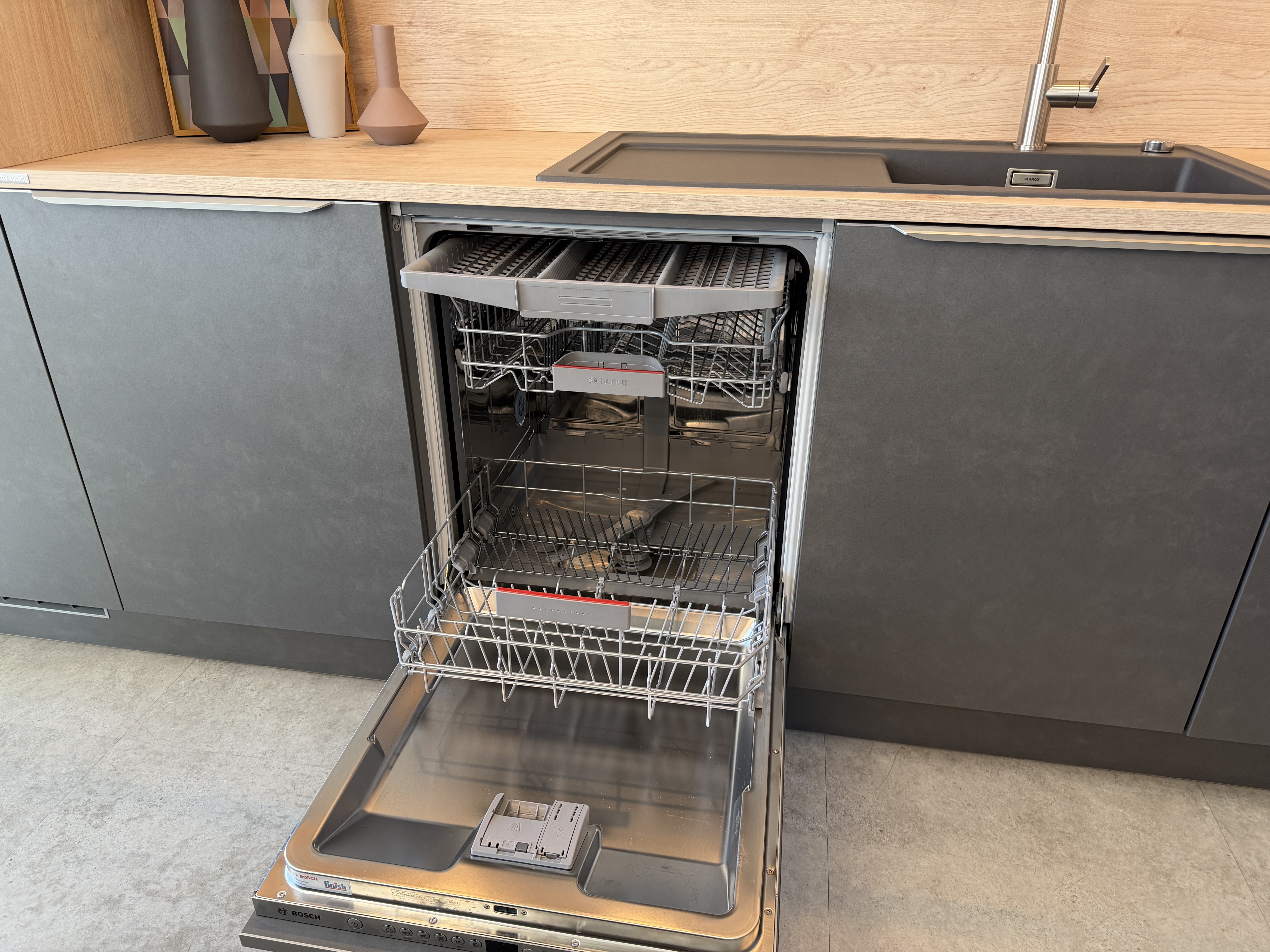 moderne Designküche in Stahl-Optik mit warmen Holzdekorelementen