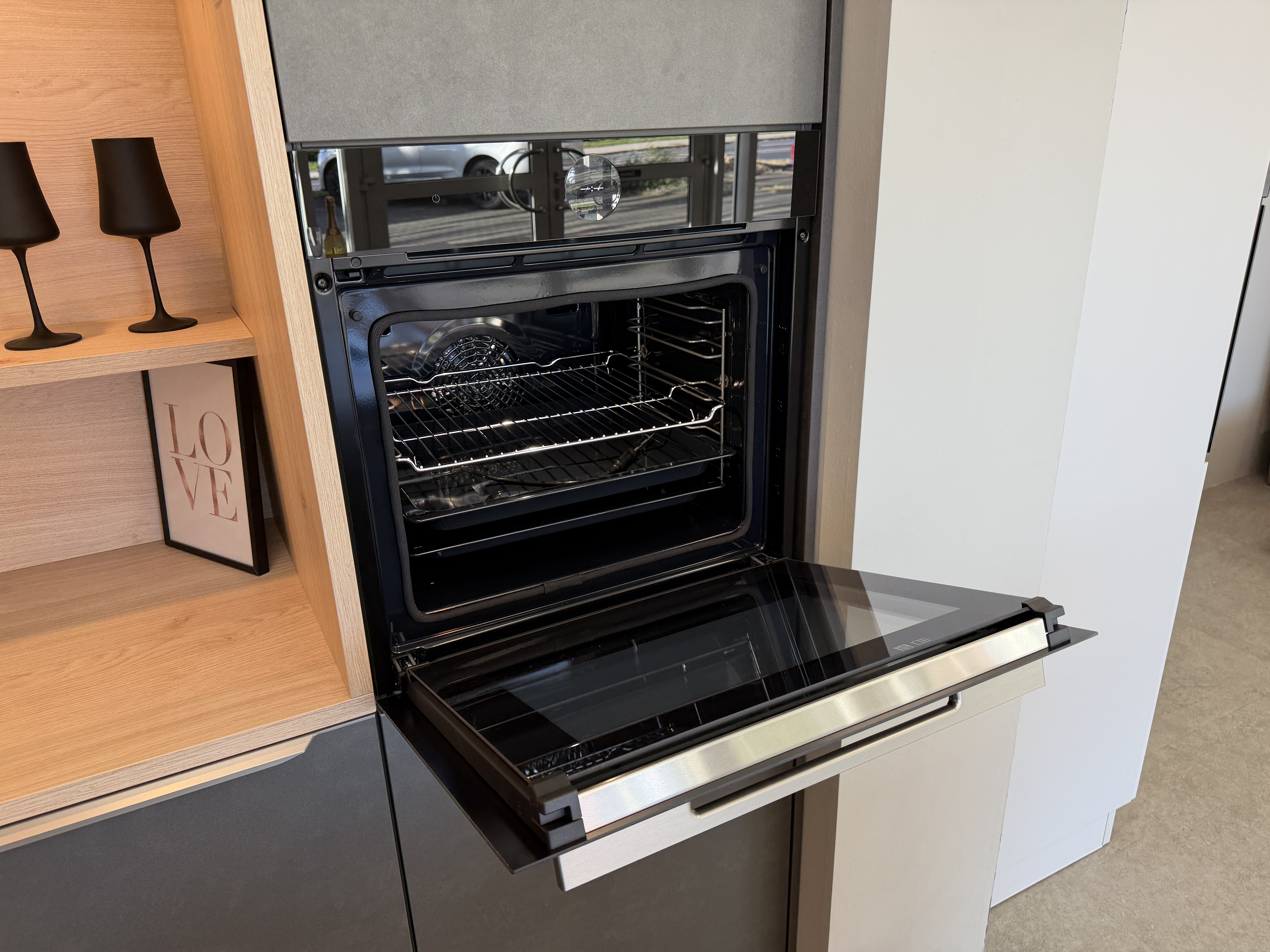 moderne Designküche in Stahl-Optik mit warmen Holzdekorelementen