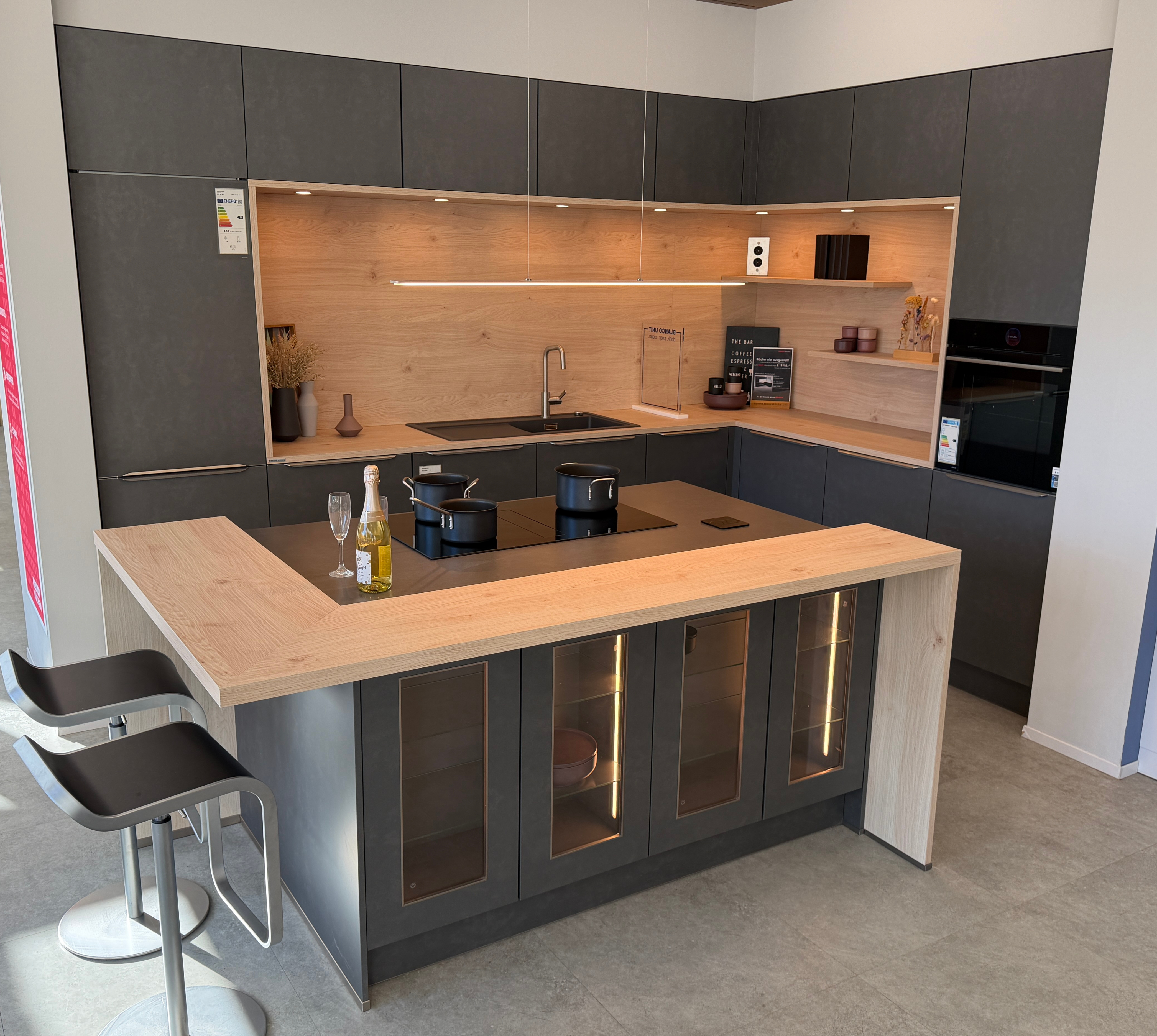 moderne Designküche in Stahl-Optik mit warmen Holzdekorelementen