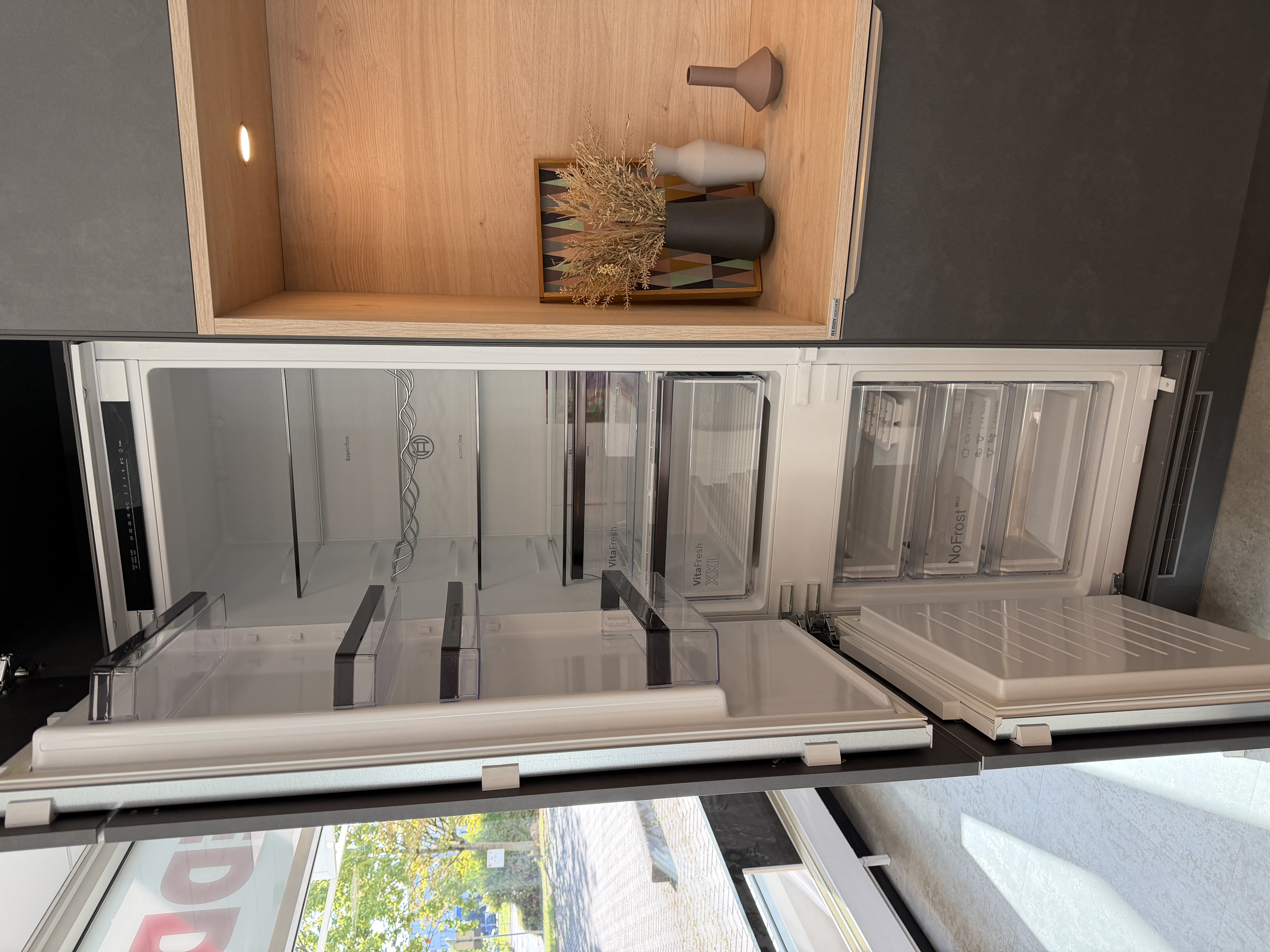 moderne Designküche in Stahl-Optik mit warmen Holzdekorelementen