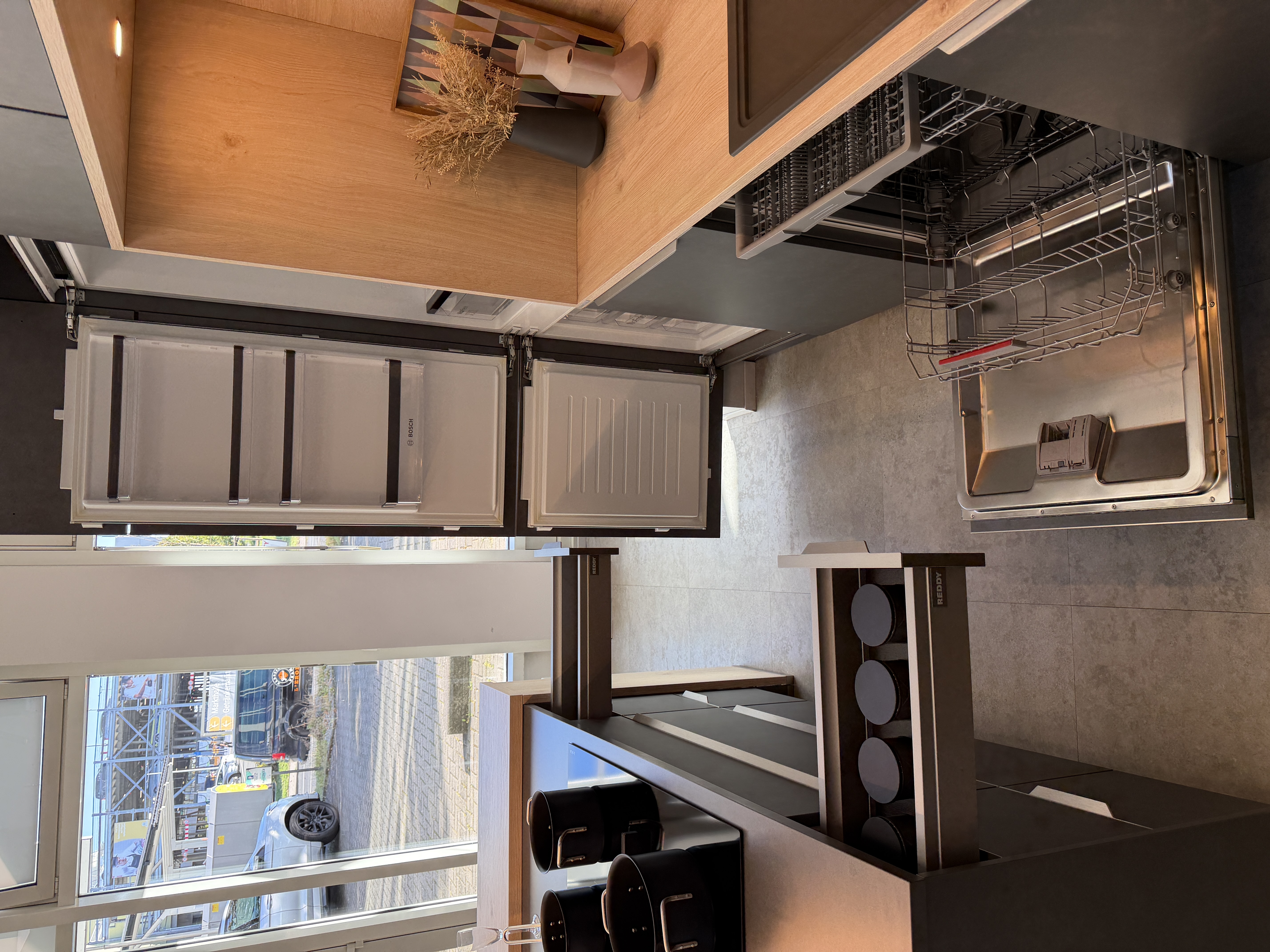 moderne Designküche in Stahl-Optik mit warmen Holzdekorelementen