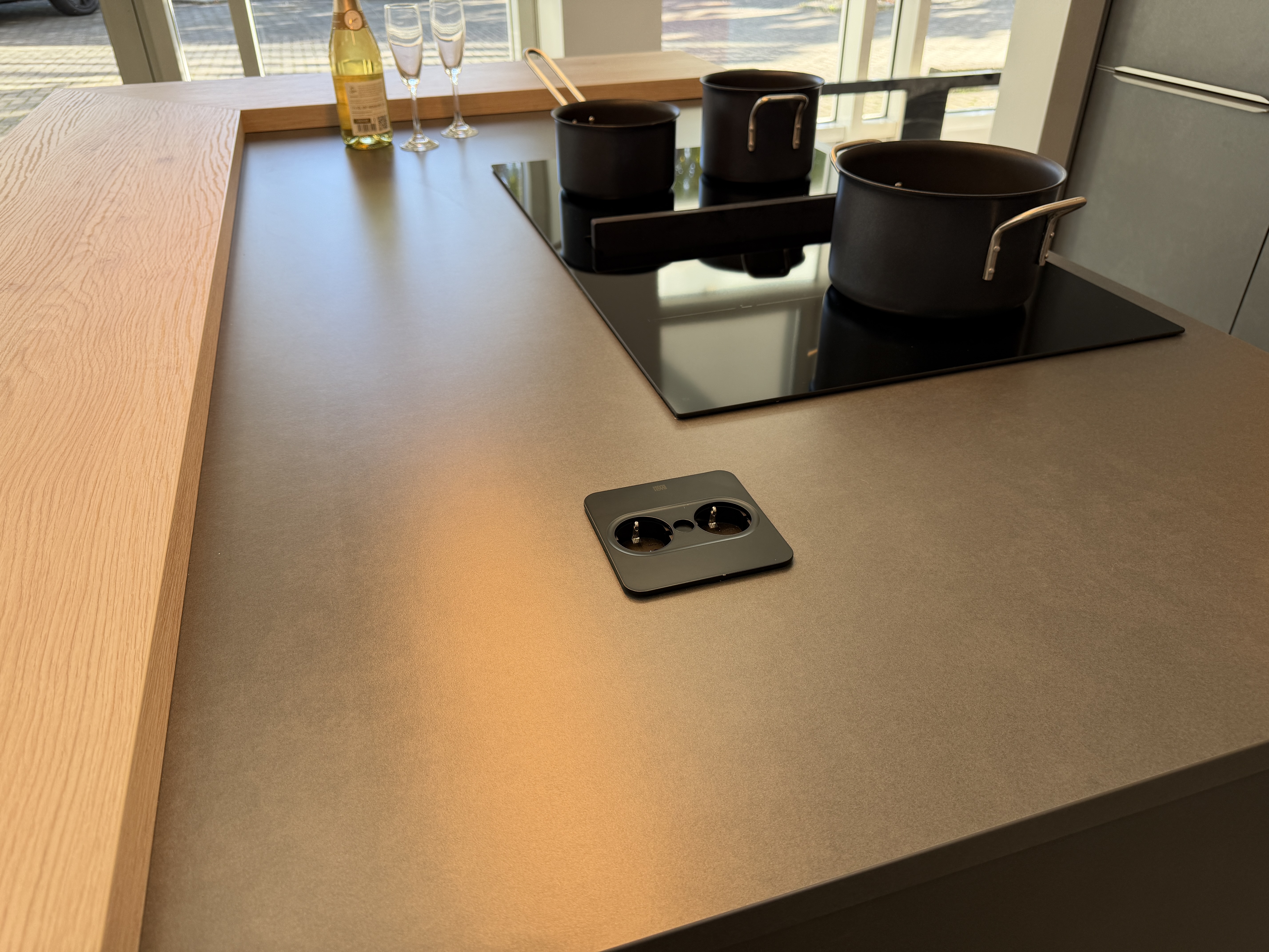 moderne Designküche in Stahl-Optik mit warmen Holzdekorelementen