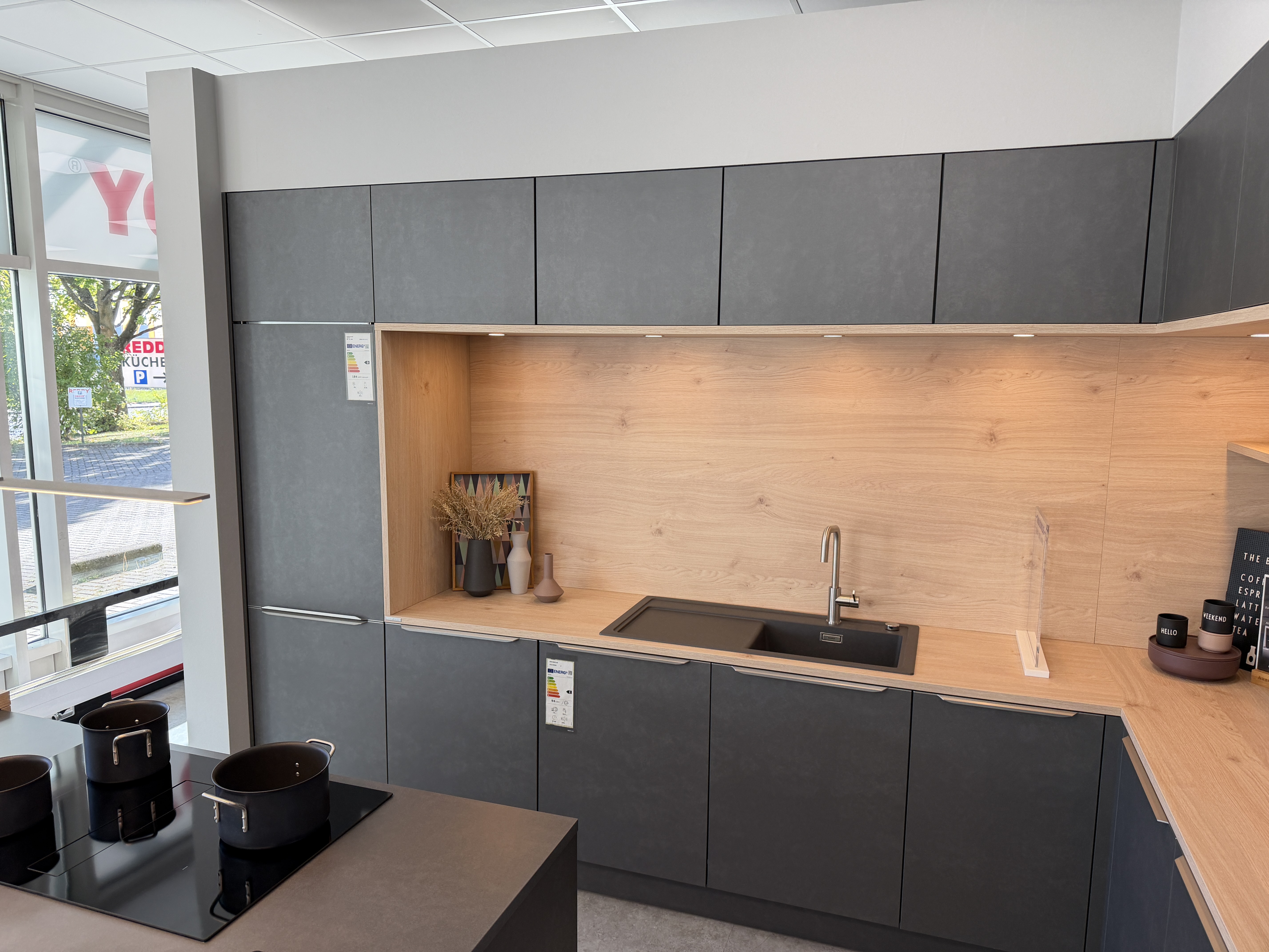 moderne Designküche in Stahl-Optik mit warmen Holzdekorelementen