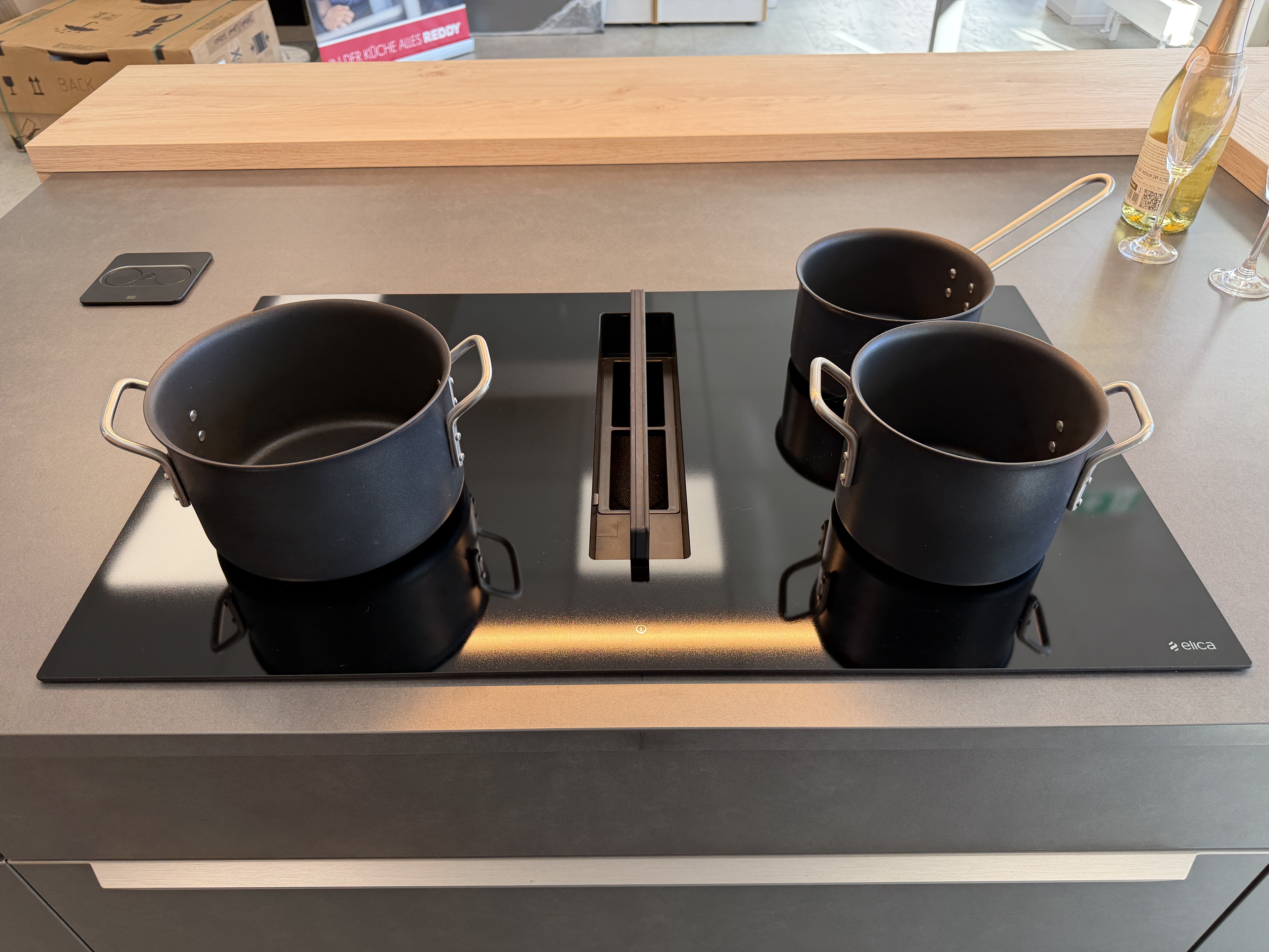 moderne Designküche in Stahl-Optik mit warmen Holzdekorelementen