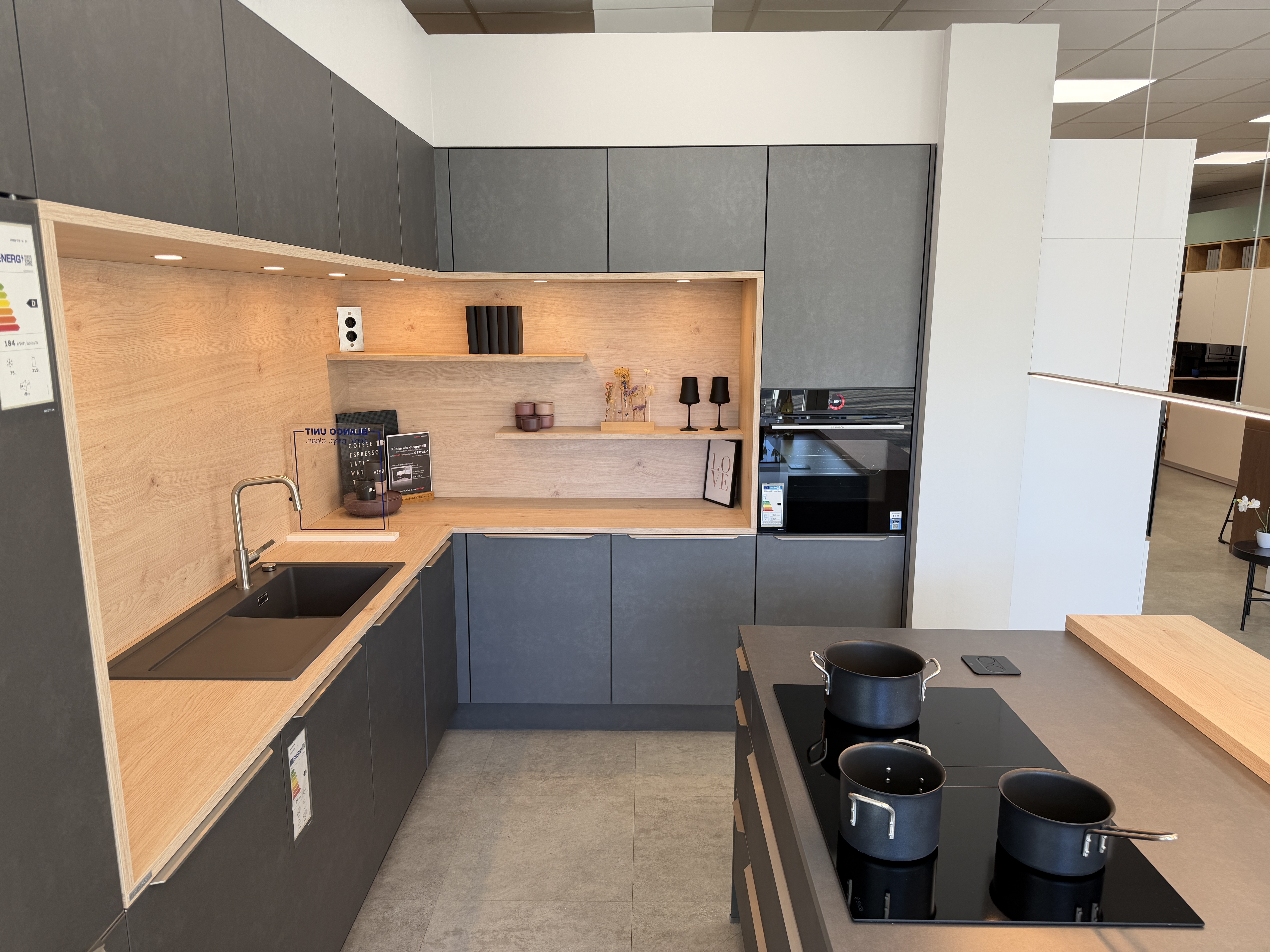 moderne Designküche in Stahl-Optik mit warmen Holzdekorelementen