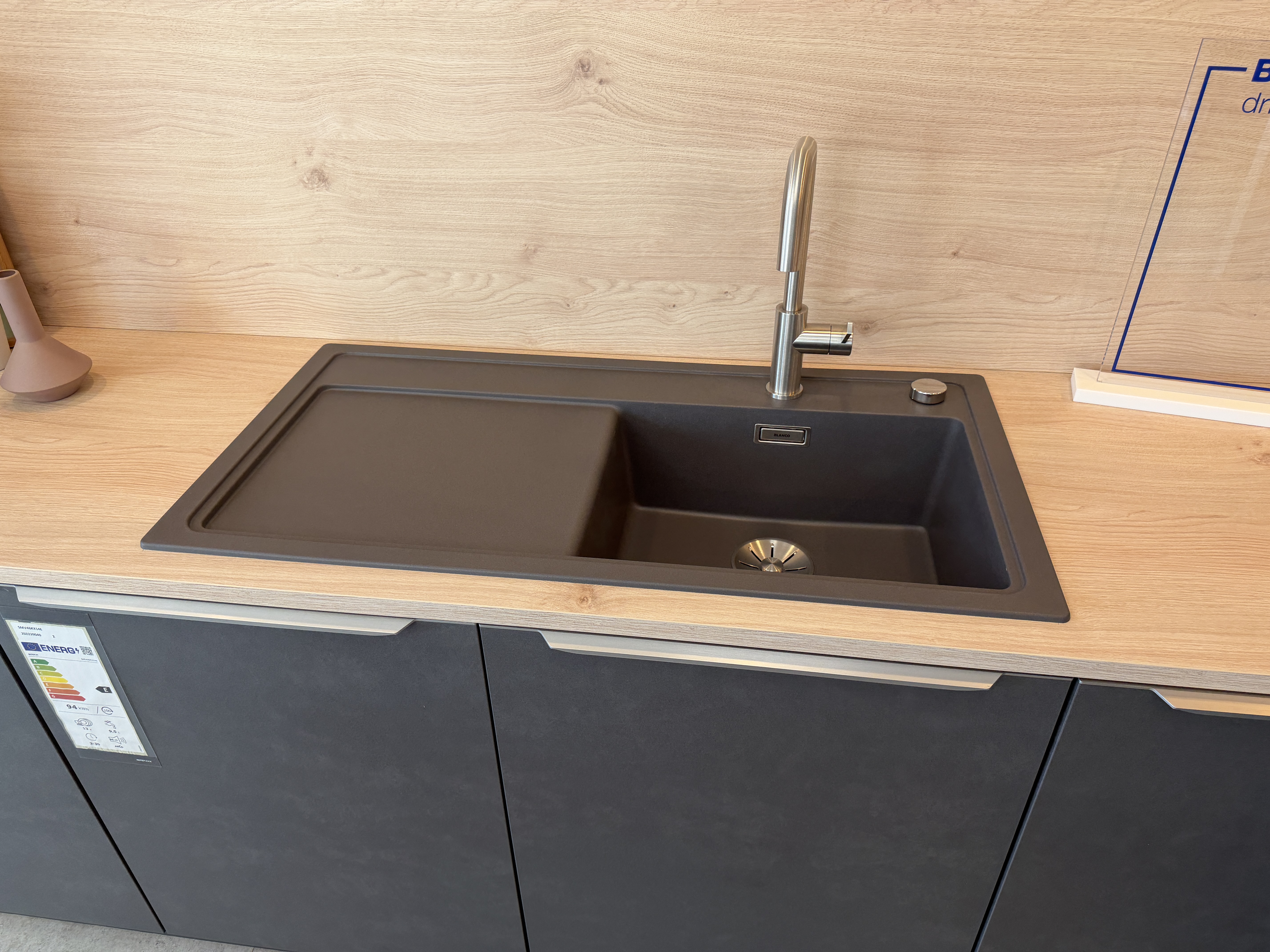 moderne Designküche in Stahl-Optik mit warmen Holzdekorelementen