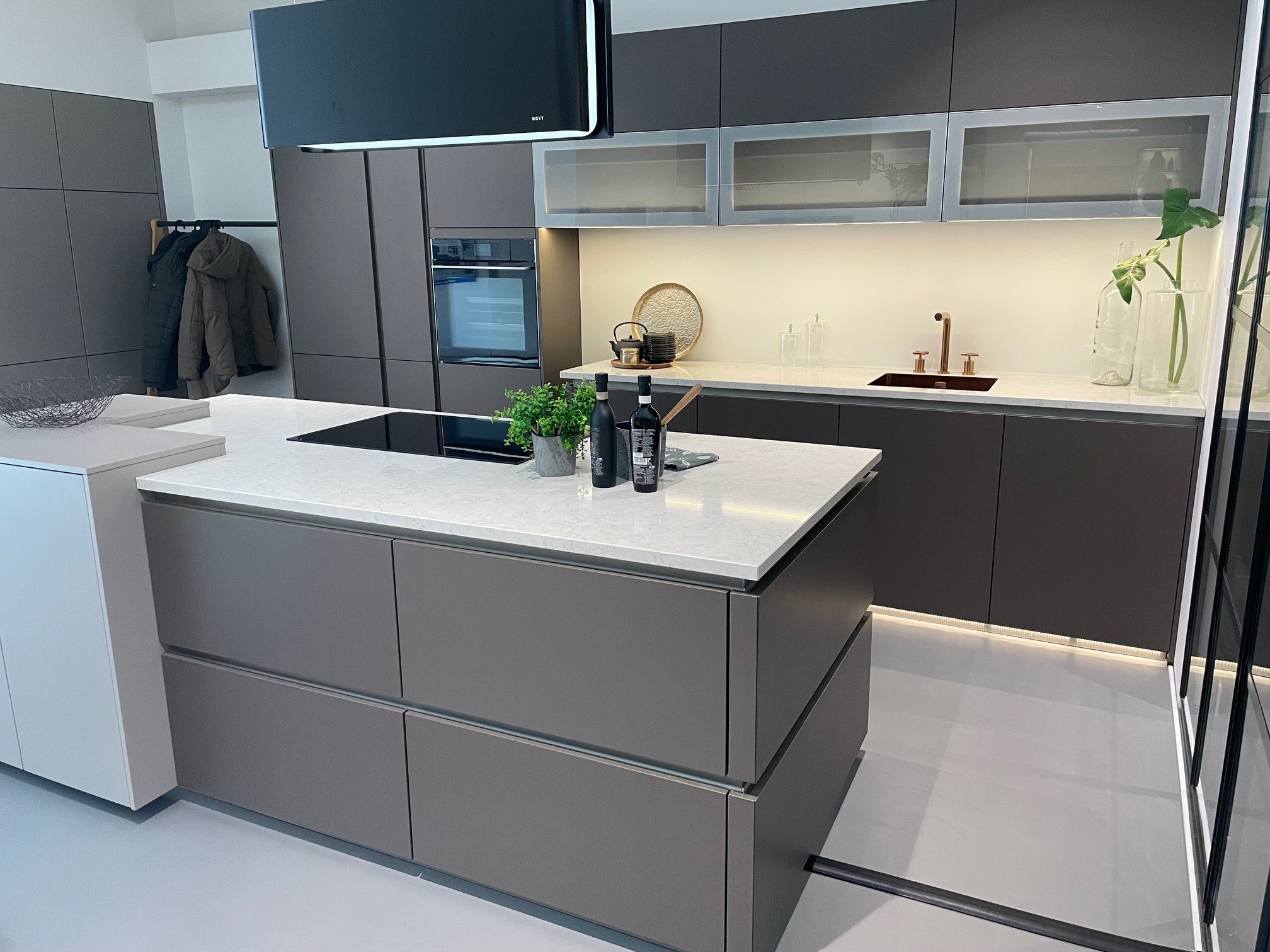 Schüller strakke showroomkeuken met eiland en luxe apparatuur.