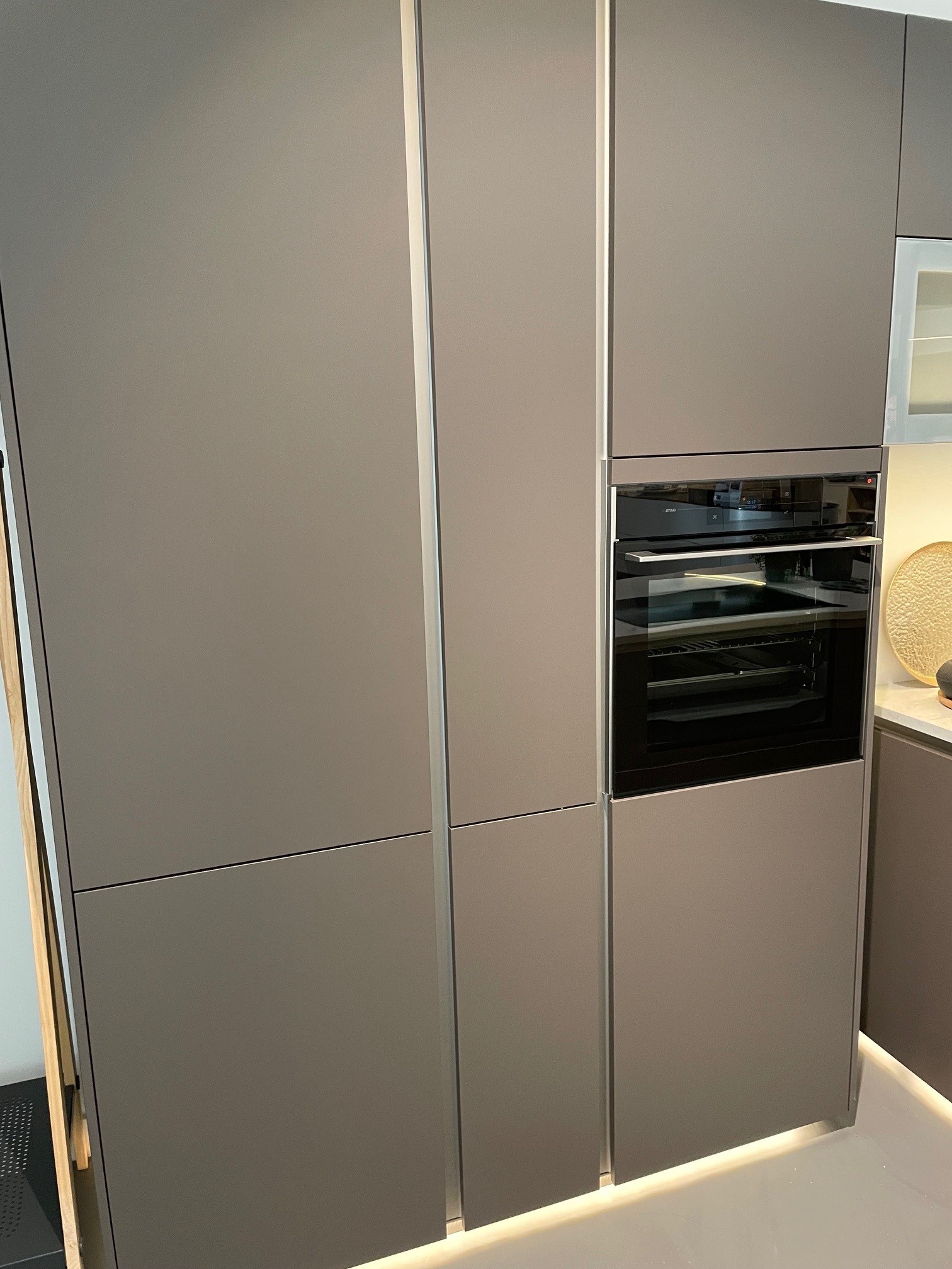Schüller strakke showroomkeuken met eiland en luxe apparatuur.