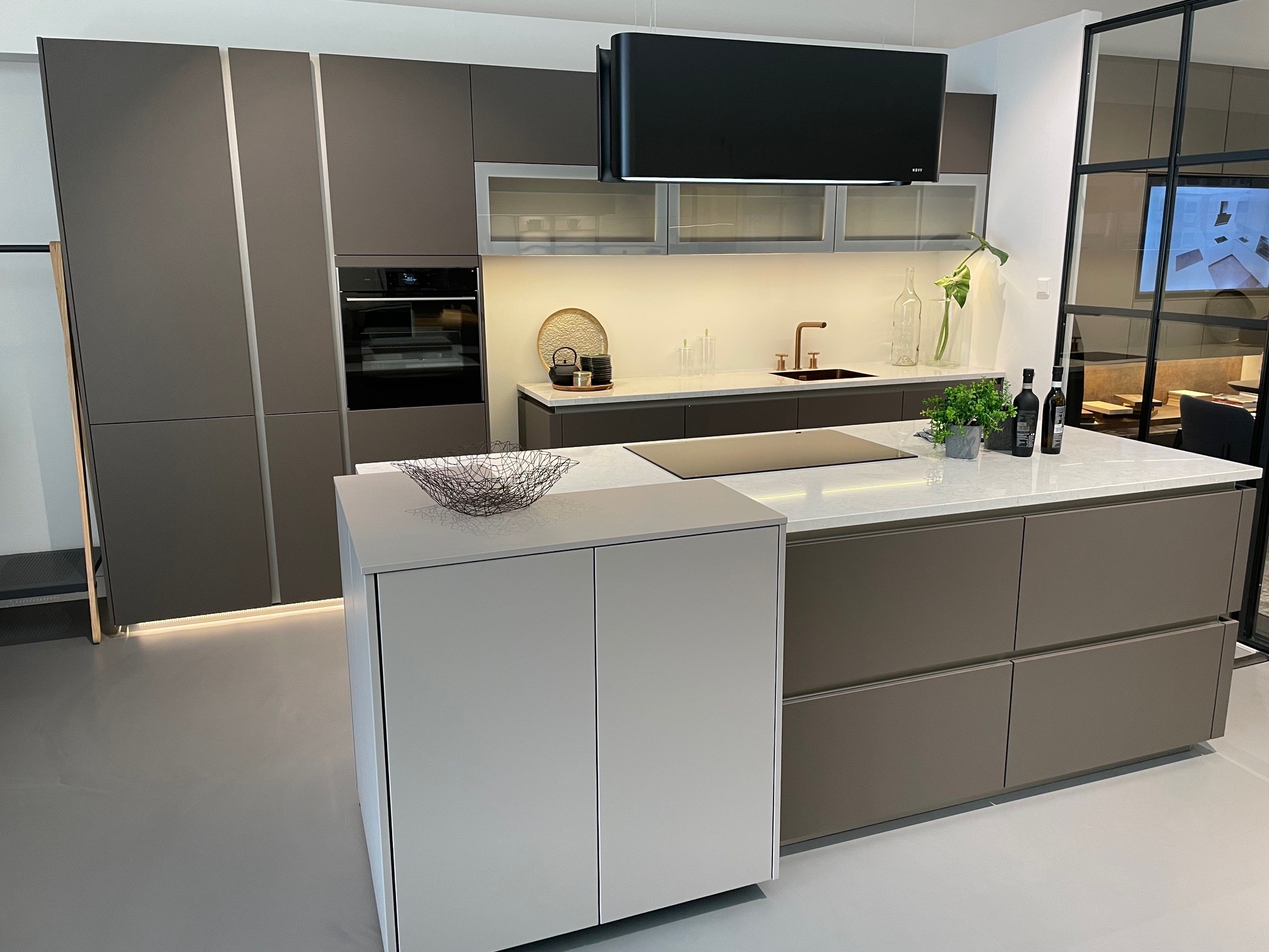 Schüller strakke showroomkeuken met eiland en luxe apparatuur.