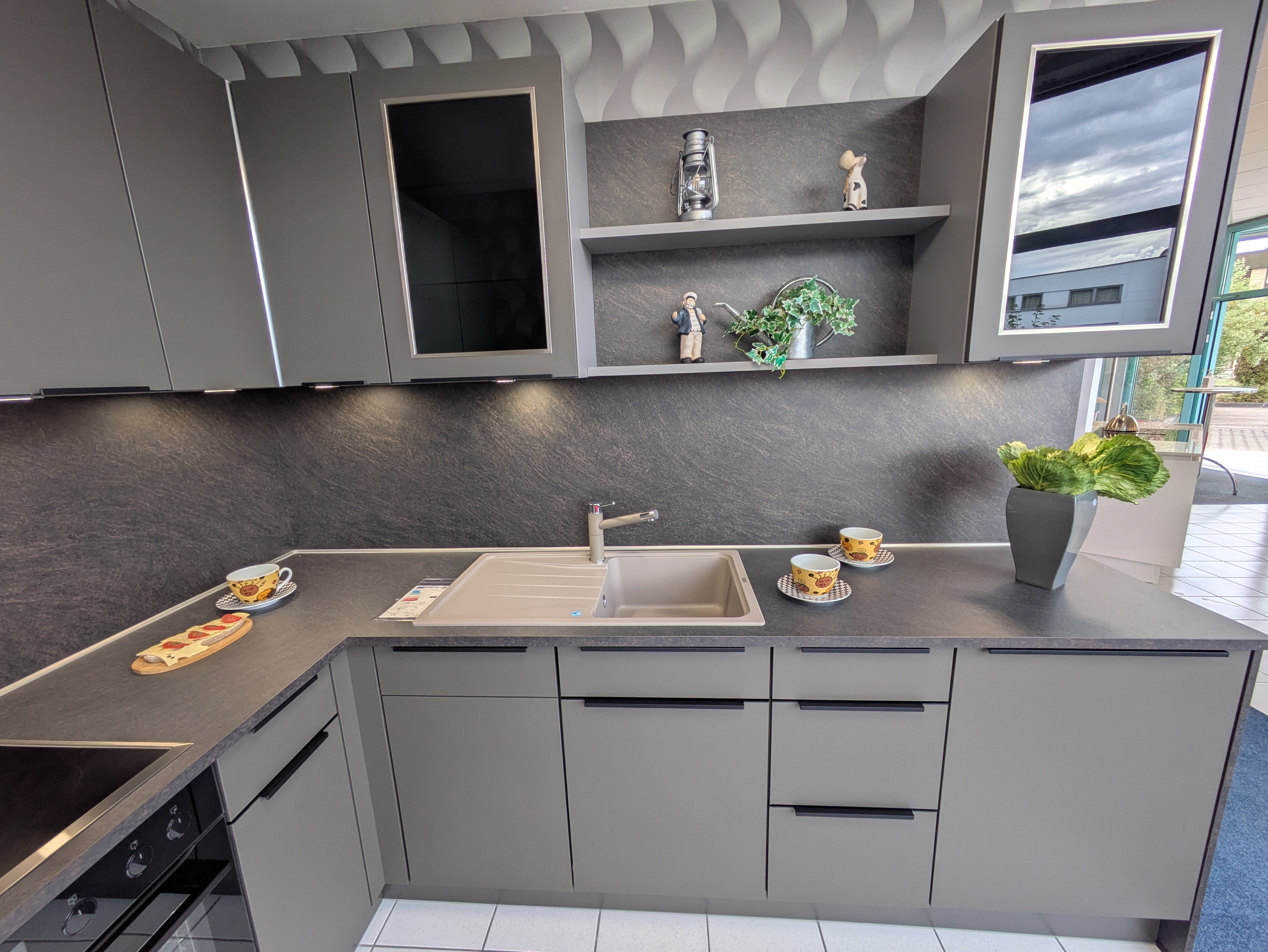 Tolle, moderne Küche in Vulkanbraun mit schwarzen Griffleisten und Rauchglas