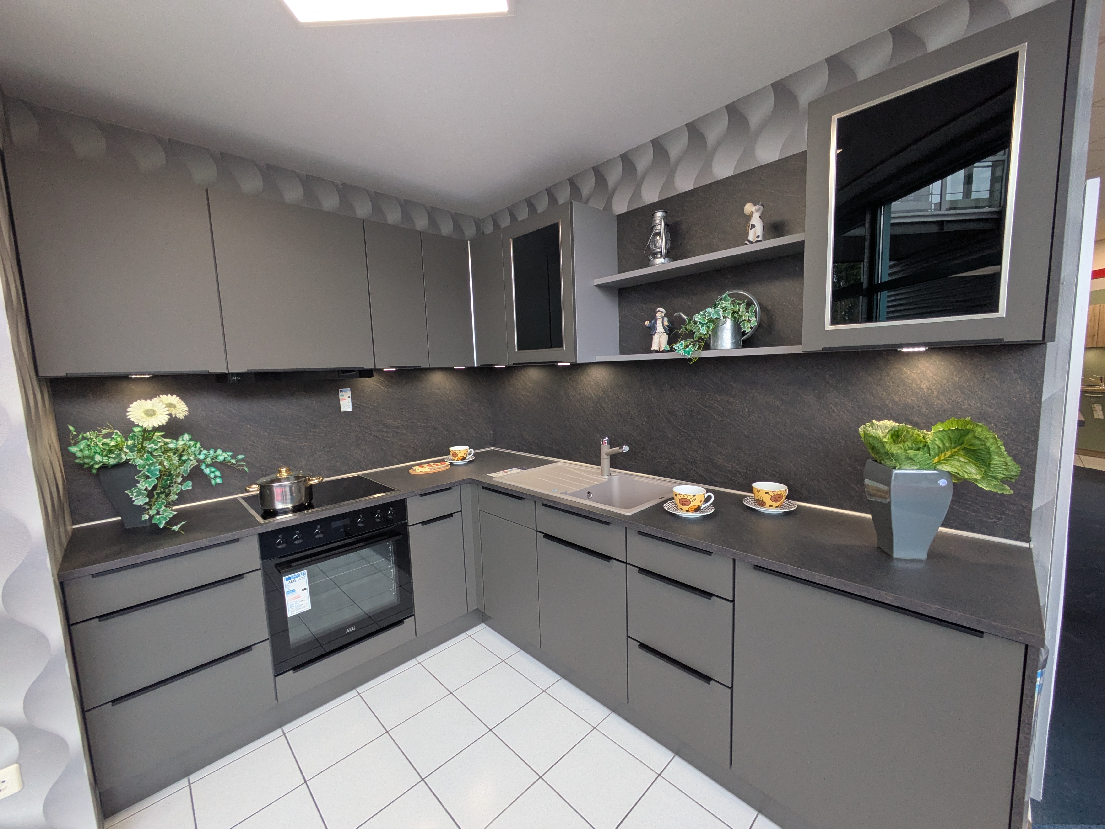 Tolle, moderne Küche in Vulkanbraun mit schwarzen Griffleisten und Rauchglas