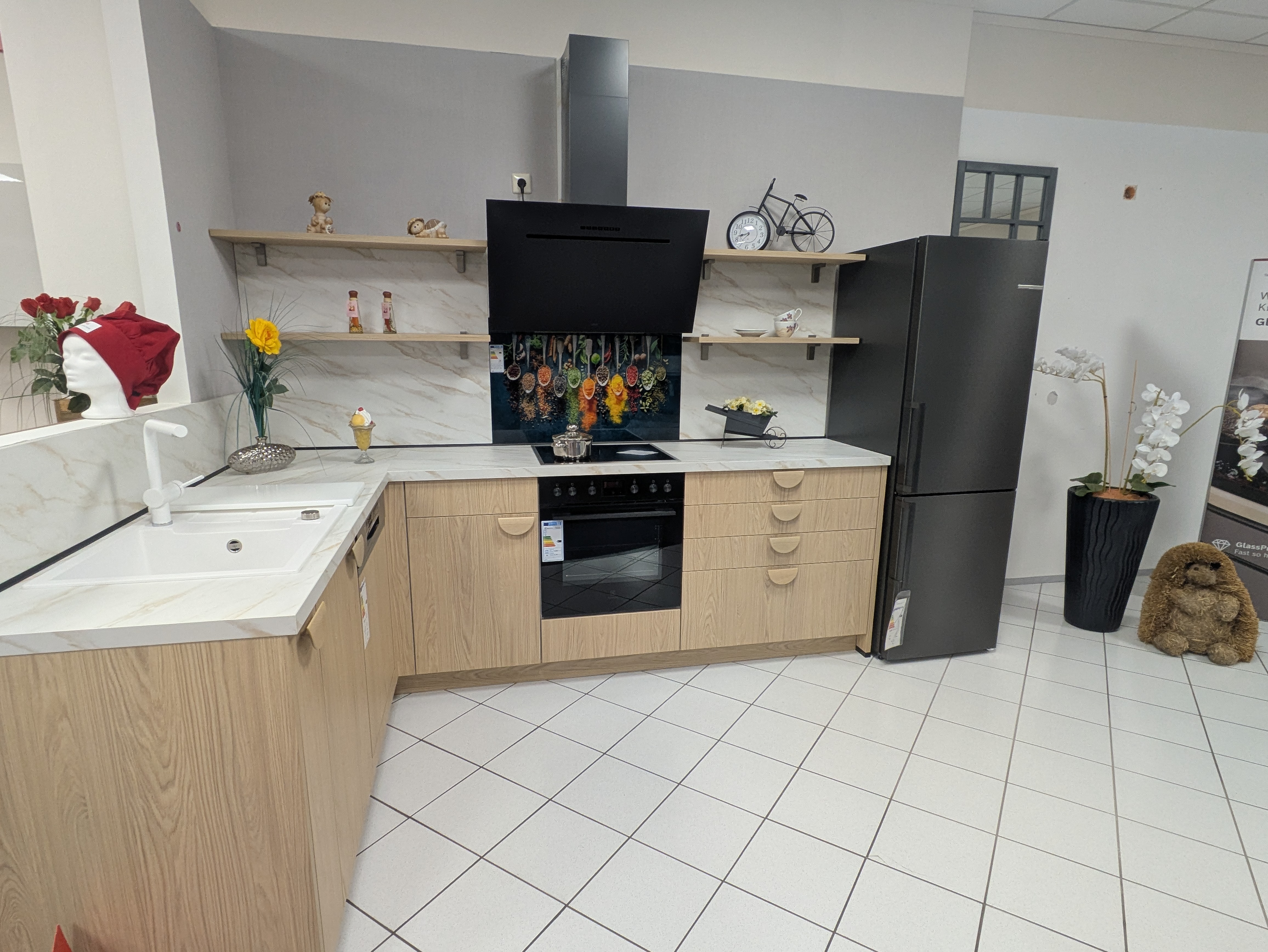 Wunderschöne L-Küche mit freistehendem Kühlschrank und großer Dunsthaube in schwarz matt