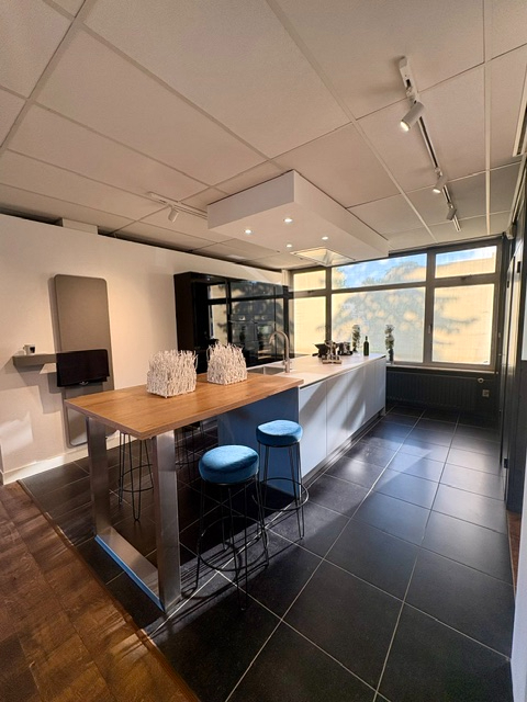 Moderne keuken met een lichtblauw eiland en keramiek marmer look blad, gecombineerd met zwarte hoogglans kasten