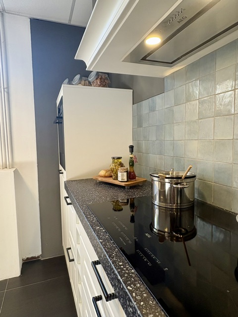 Klassieke keuken met een mat wit gelakt kaderdeur en een zwart composiet blad