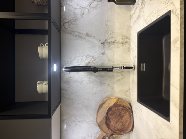 Minimalistische moderne keuken met een grafiet meubel en een keramiek marmer look, glanzend blad