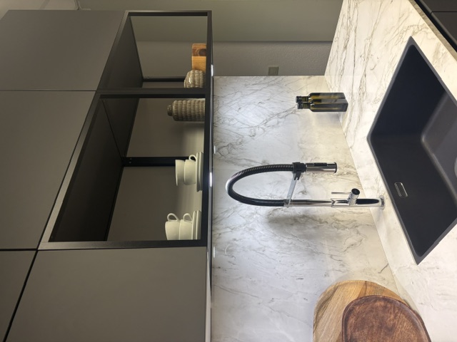 Minimalistische moderne keuken met een grafiet meubel en een keramiek marmer look, glanzend blad
