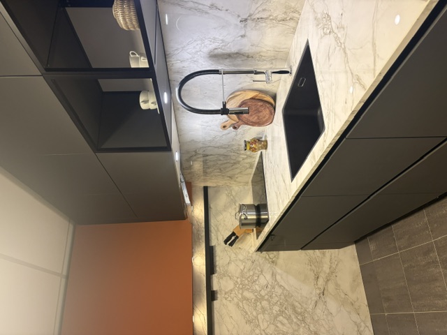 Minimalistische moderne keuken met een grafiet meubel en een keramiek marmer look, glanzend blad