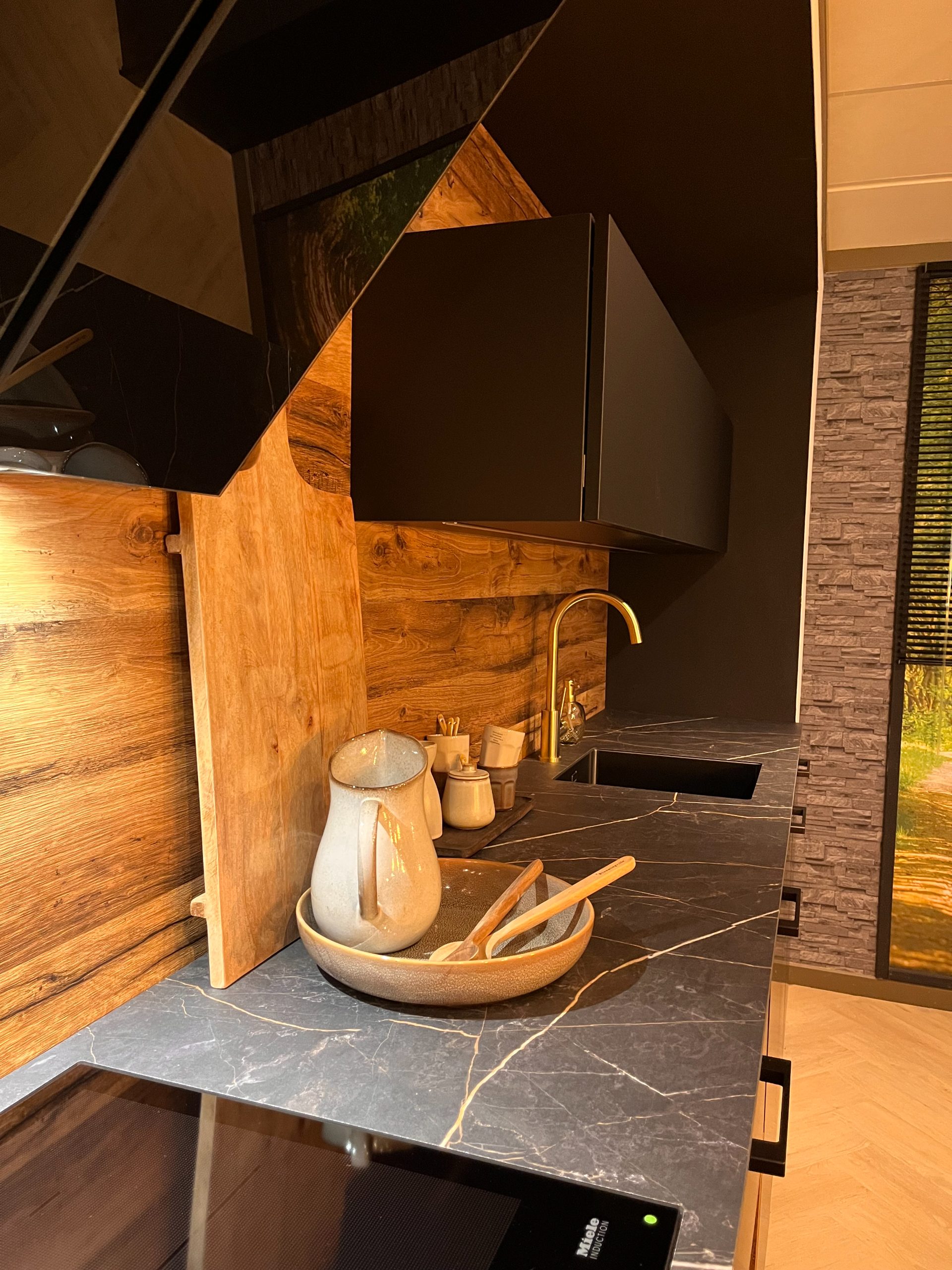 Luxe showroomkeuken in mat zwart en warm hout